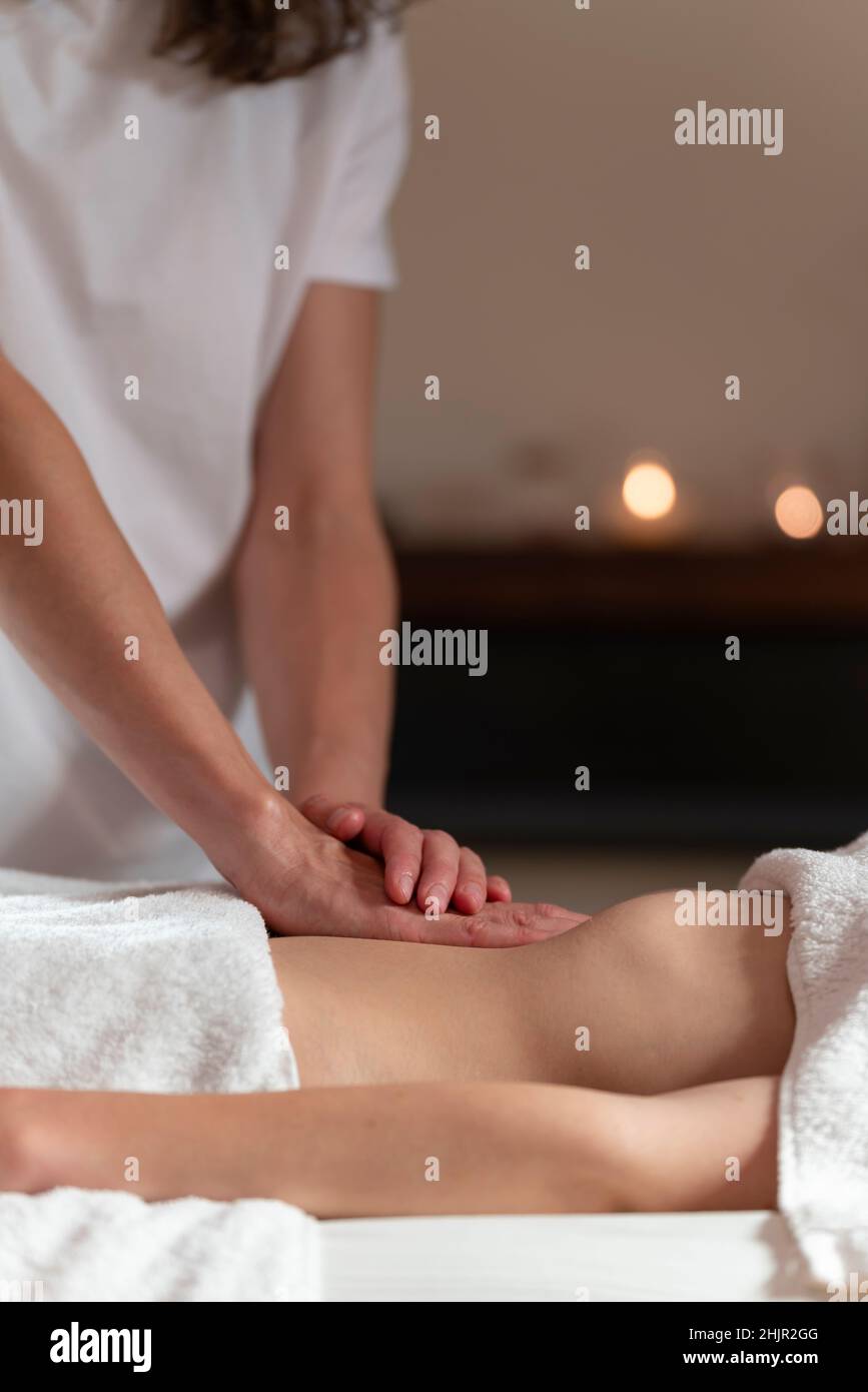 A masseuse woman doing an oil massage to another woman on the stomach Stock Photo
