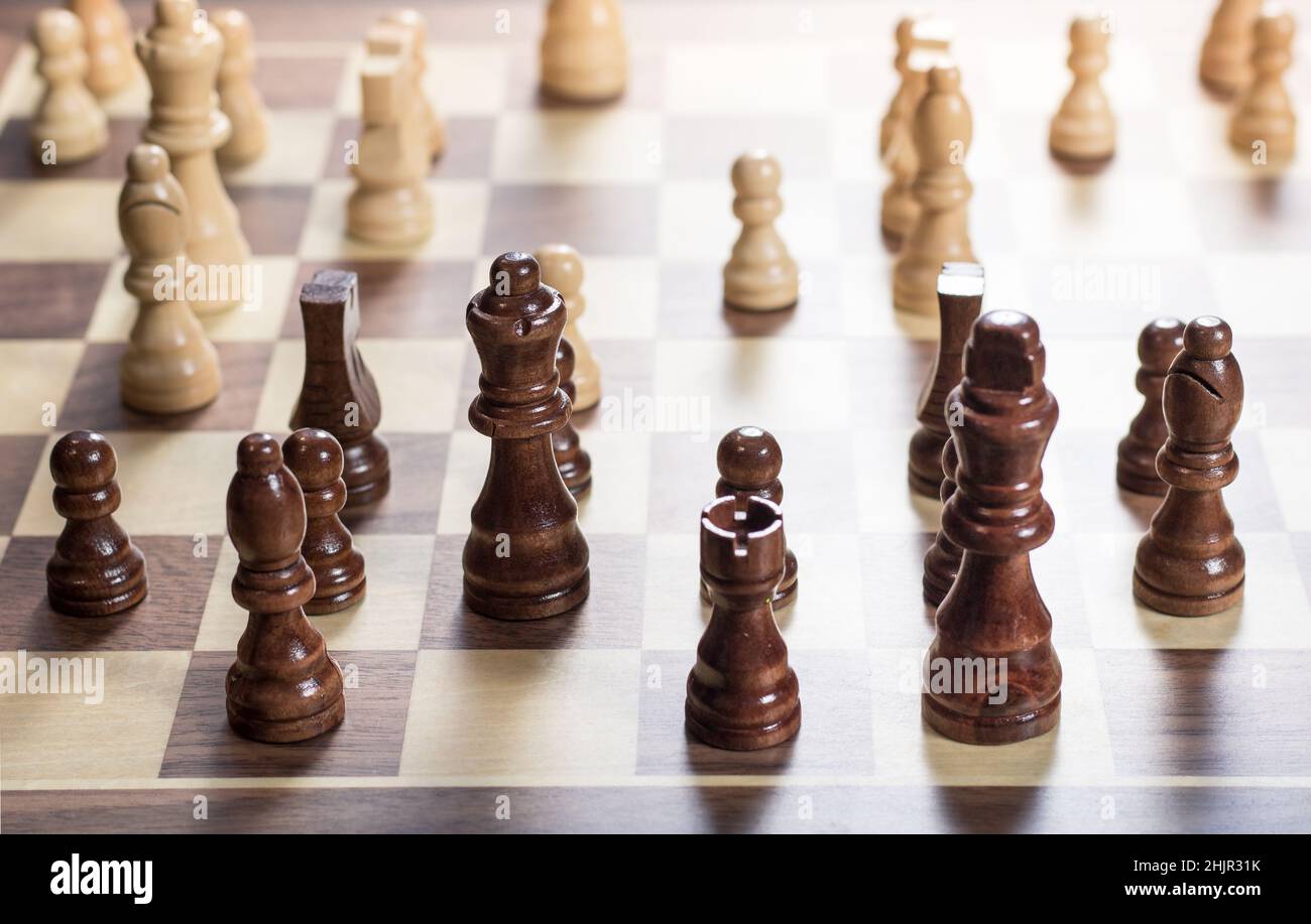 Chess board with chess game being played. Top down angle. Black pieces in foreground Stock Photo