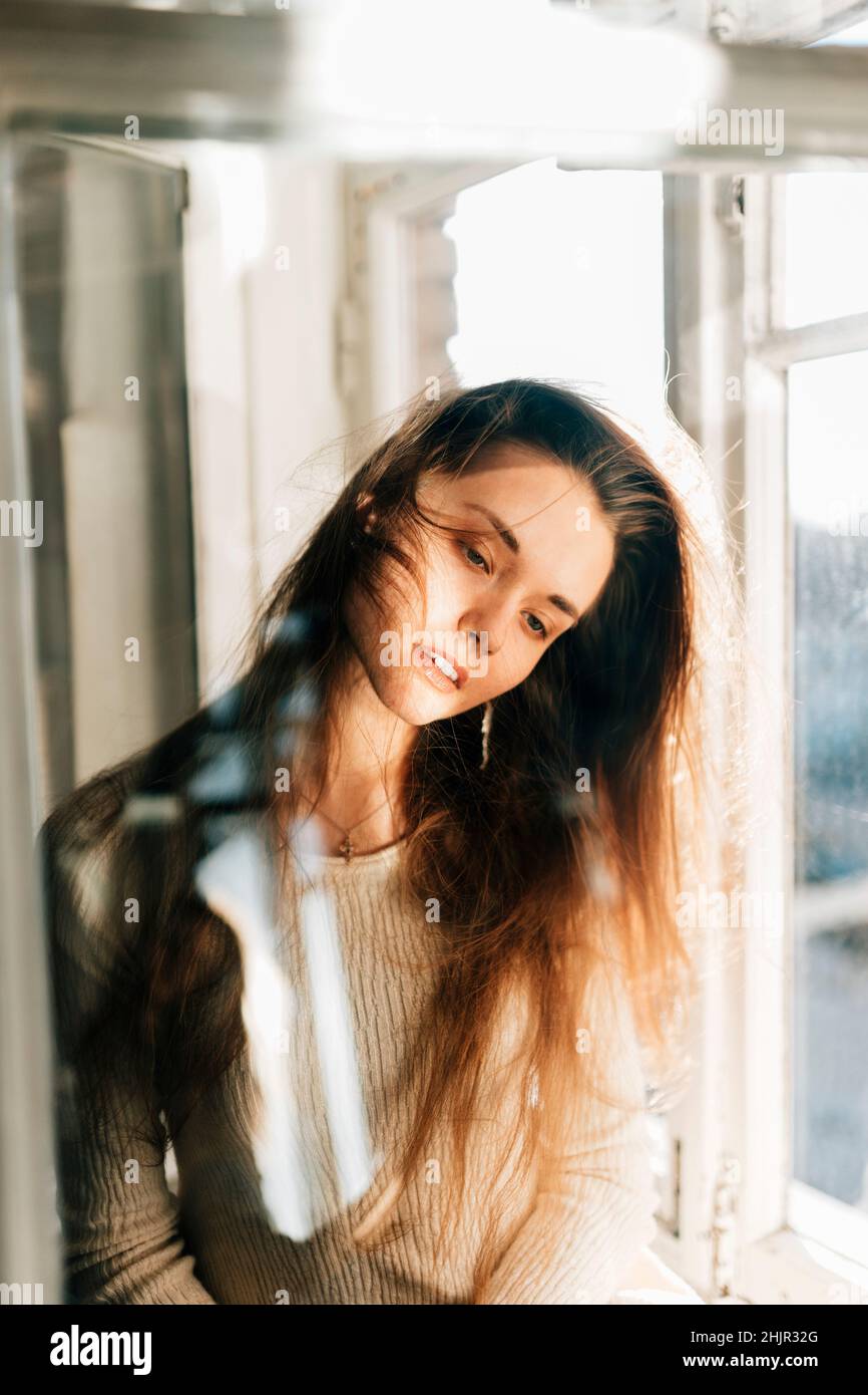 Portrait of a young woman seen through the window. Stock Photo