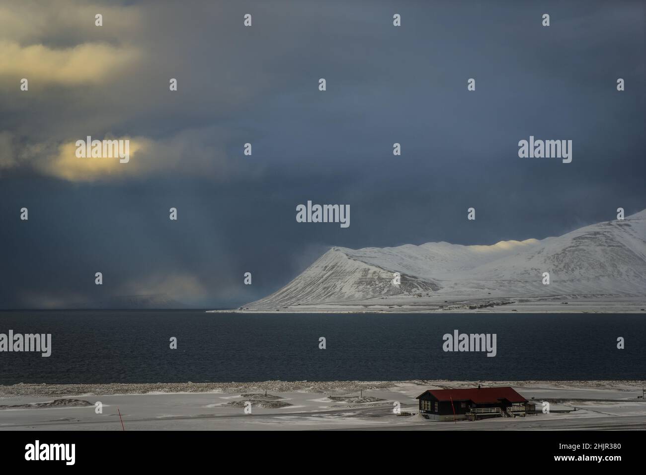 Sunlight piercing through clouds in Longyearbyen bay Stock Photo
