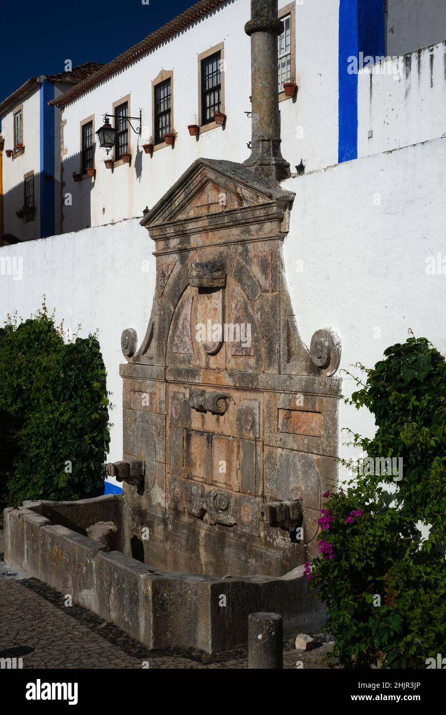 Drinking water fountain and public monument, commissioned in 1575 by Queen Catherine of Austria, in the central square of Óbidos, Portugal Stock Photo