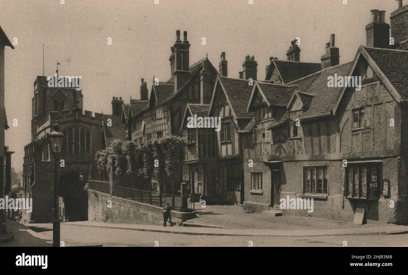 In ancient Warwick, close to the 12C West Gate is the late 14th century-lord Leycester's Hospital, an asylum for 12 poor brethren. Warwickshire (1923) Stock Photo
