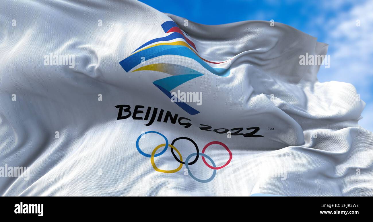 Beijing, CHN, Jan. 2022: Beijing 2022 flag waving in the wind with the Olympic flag blurred in the foreground. Beijing 2022 winter olympics games are Stock Photo