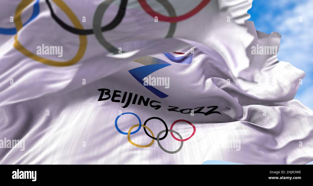 Beijing, CHN, Jan. 2022: Beijing 2022 flag waving in the wind with the Olympic flag blurred in the foreground. Beijing 2022 winter olympics games are Stock Photo