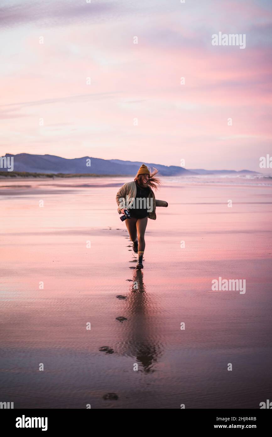 Smiling Young Female Photographer on Oregon beach at sunrise Stock Photo
