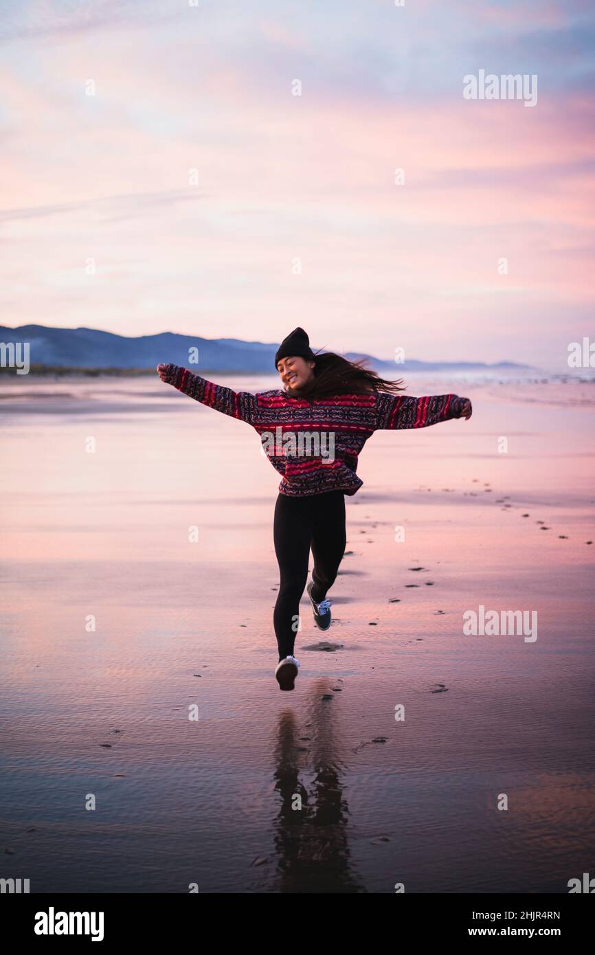 Smiling Young Asian Woman on Oregon beach at sunrise Stock Photo