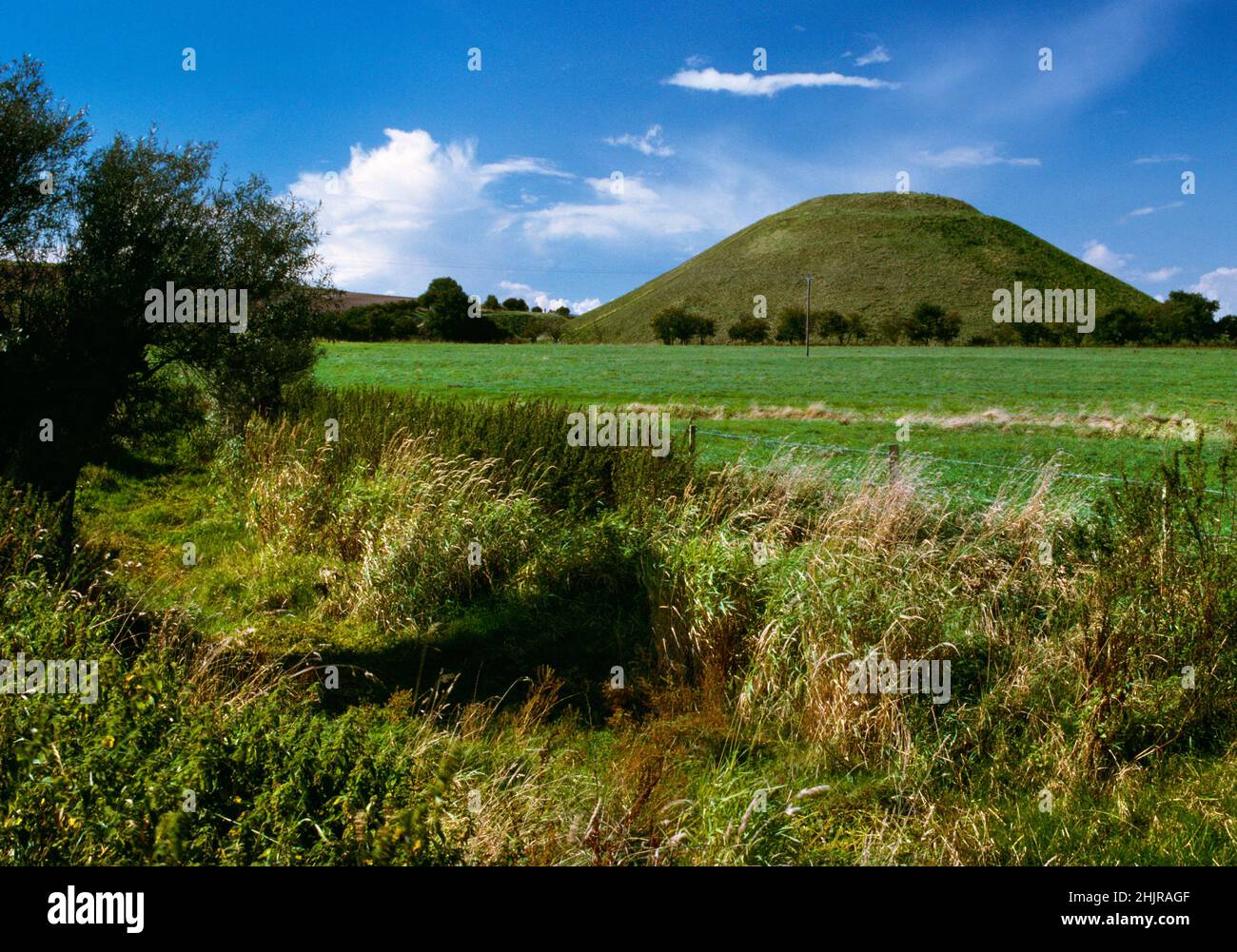Silbury Hill Late Neolithic artificial mound (the largest in Europe), West Kennet, Avebury, UK, looking W over the course of the Winterbourne stream. Stock Photo
