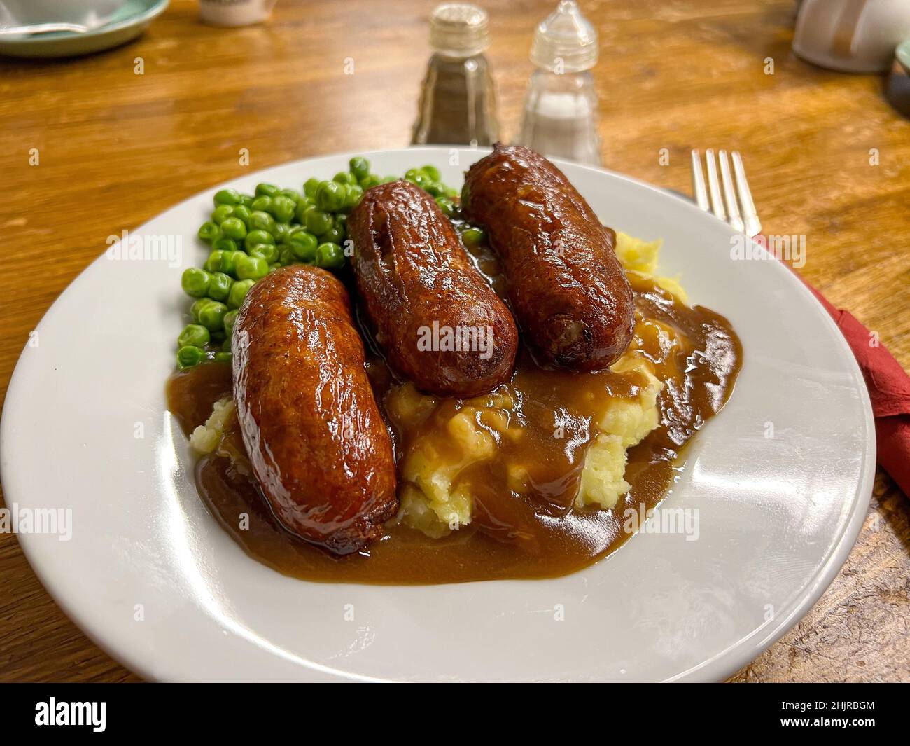 Sausage and mash dinner with peas and gravy Stock Photo Alamy