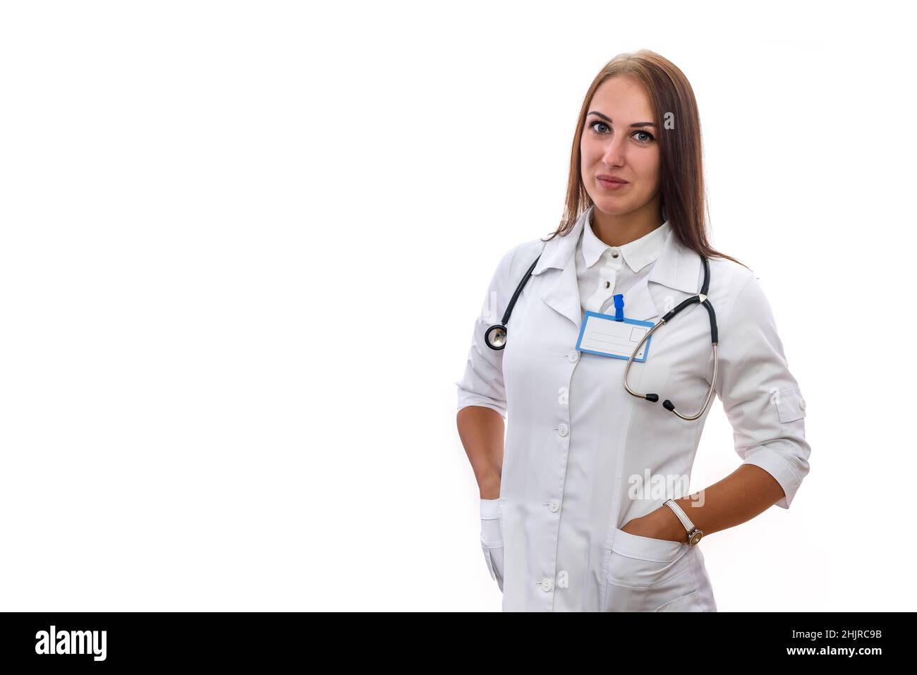 Smiling woman in white medical coat posing with stethoscope isolated on white Stock Photo