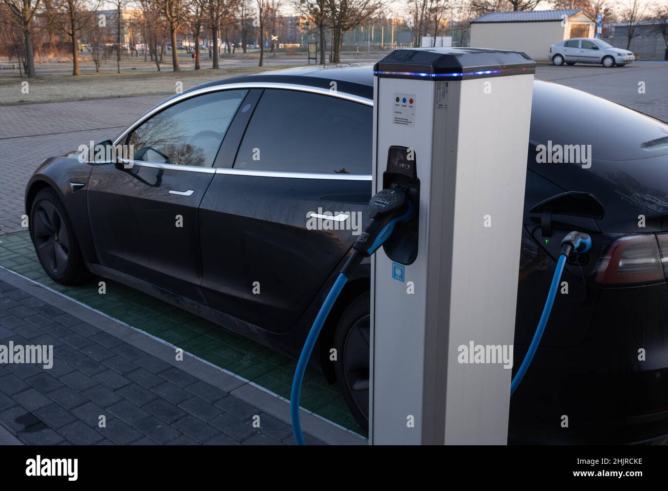 Skarbimierz Osiedle, Poland - January 9, 2022. A static shot of a solid black Tesla Model 3 dual motor charging at the EV+ AC charging station in a su Stock Photo