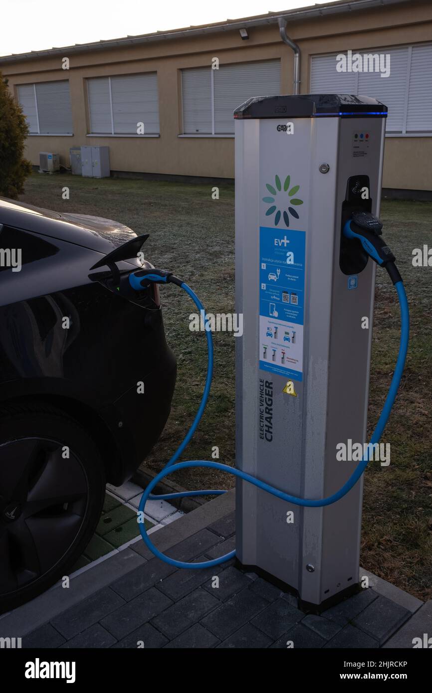 Skarbimierz Osiedle, Poland - January 9, 2022. A static shot of a solid black Tesla Model 3 dual motor charging at the EV+ AC charging station in a su Stock Photo