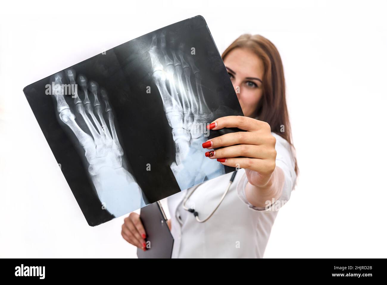 Doctor examining x-ray. Beautiful woman in medical coat with patient's x-ray isolated on white Stock Photo