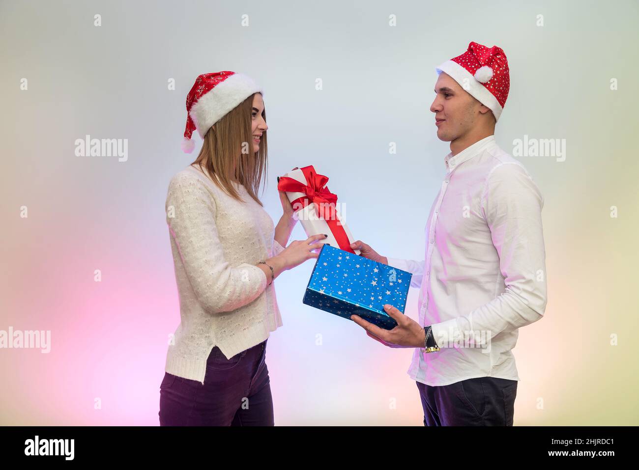 Young, fashion couple celebrating St. Valentine's Day giving presents to each other Stock Photo