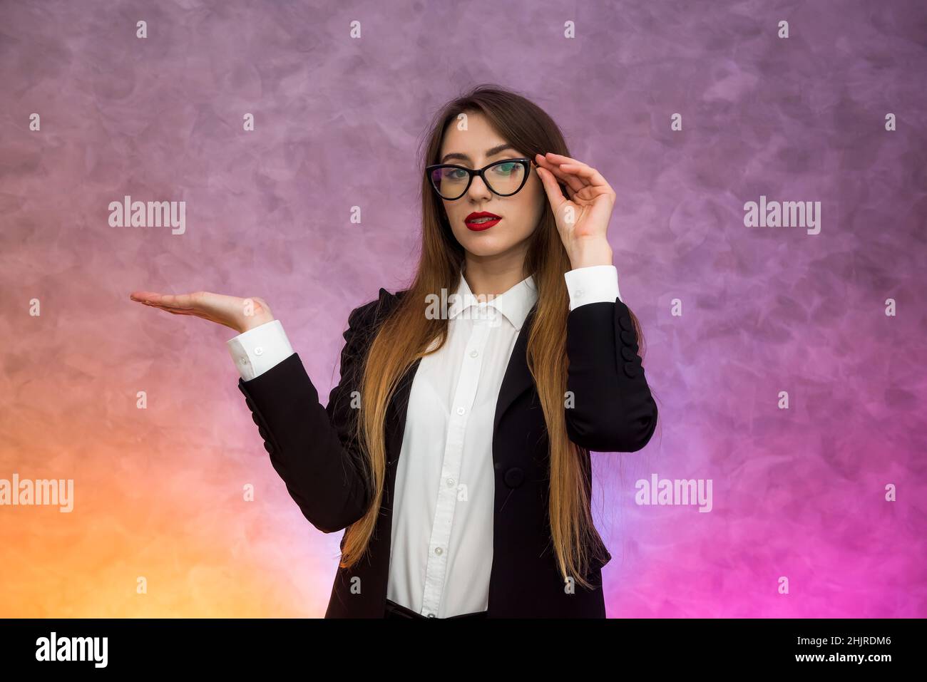 Attractive business woman gesturing ob abstract background in original spectacles Stock Photo