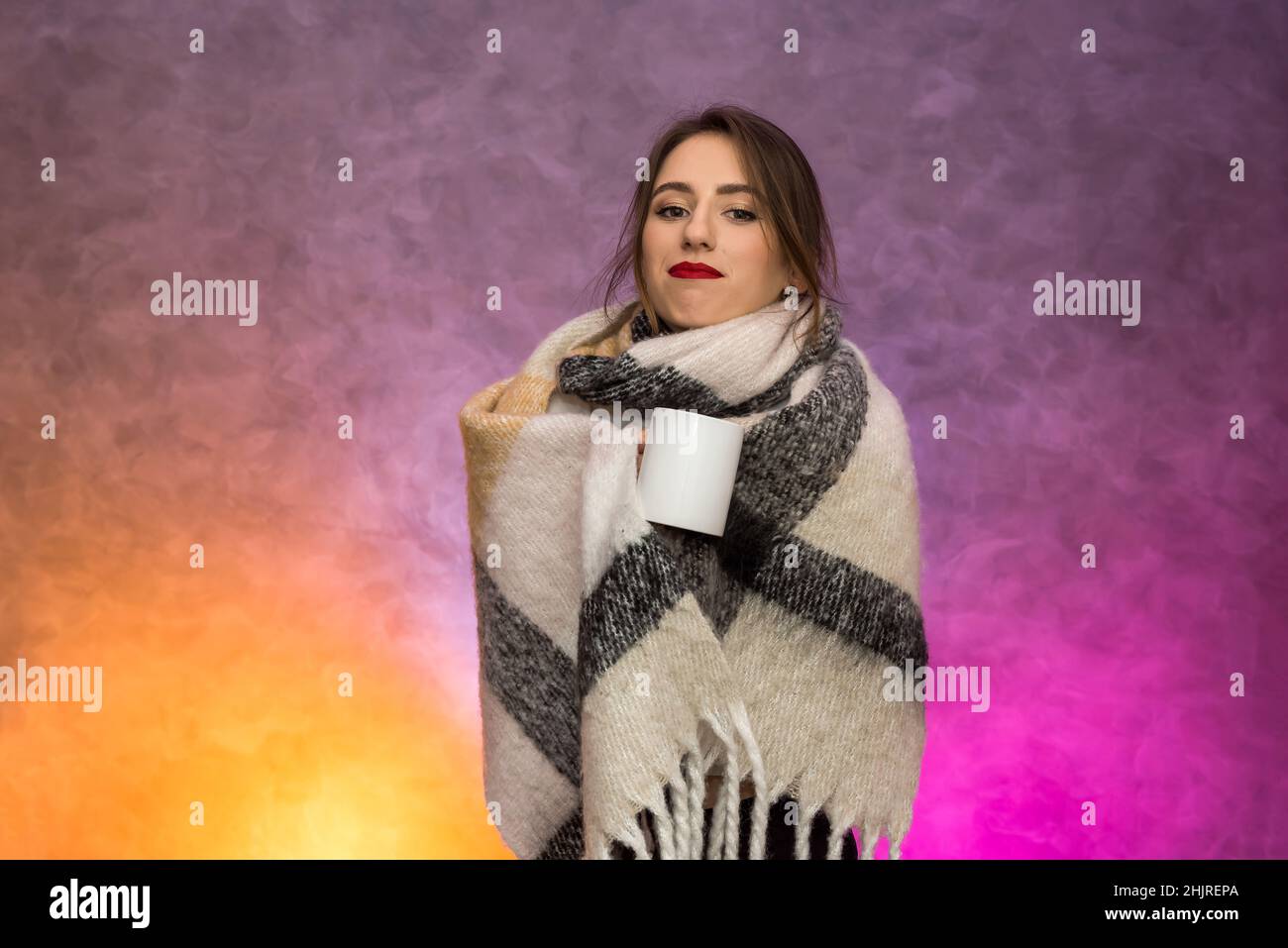 Sickness concept. Woman with warm blanket and hot tea cup posing with very sad emotions Stock Photo