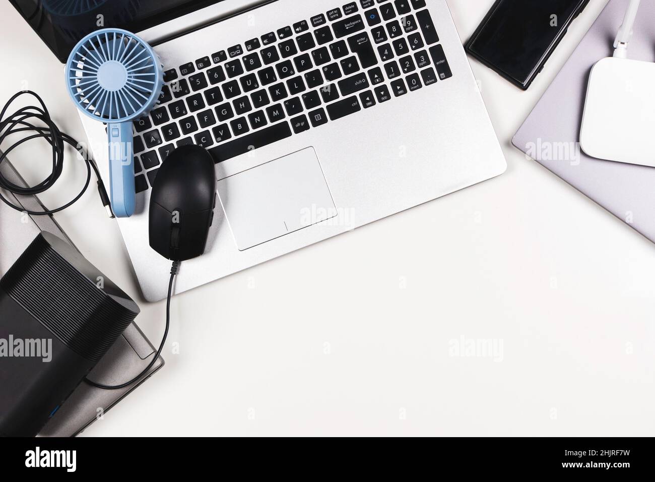 Top view to old laptop computers, digital tablets, mobile phones, many used electronic gadgets devices on white table. Planned obsolescence, e-waste Stock Photo