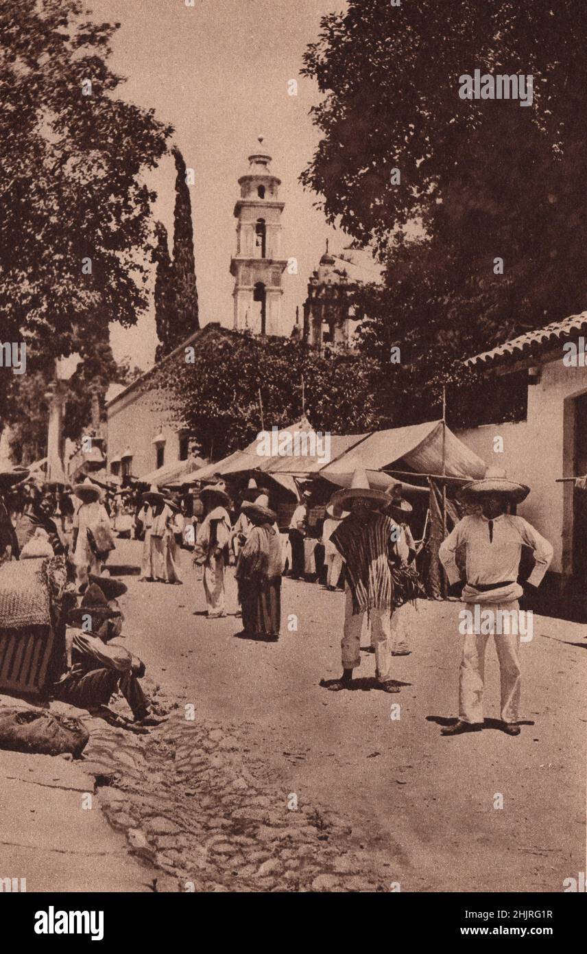 The main Street in San Antone basks under the trees in the sun-flooded valley of Cuernavaca on a fiesta day. Mexico (1923) Stock Photo