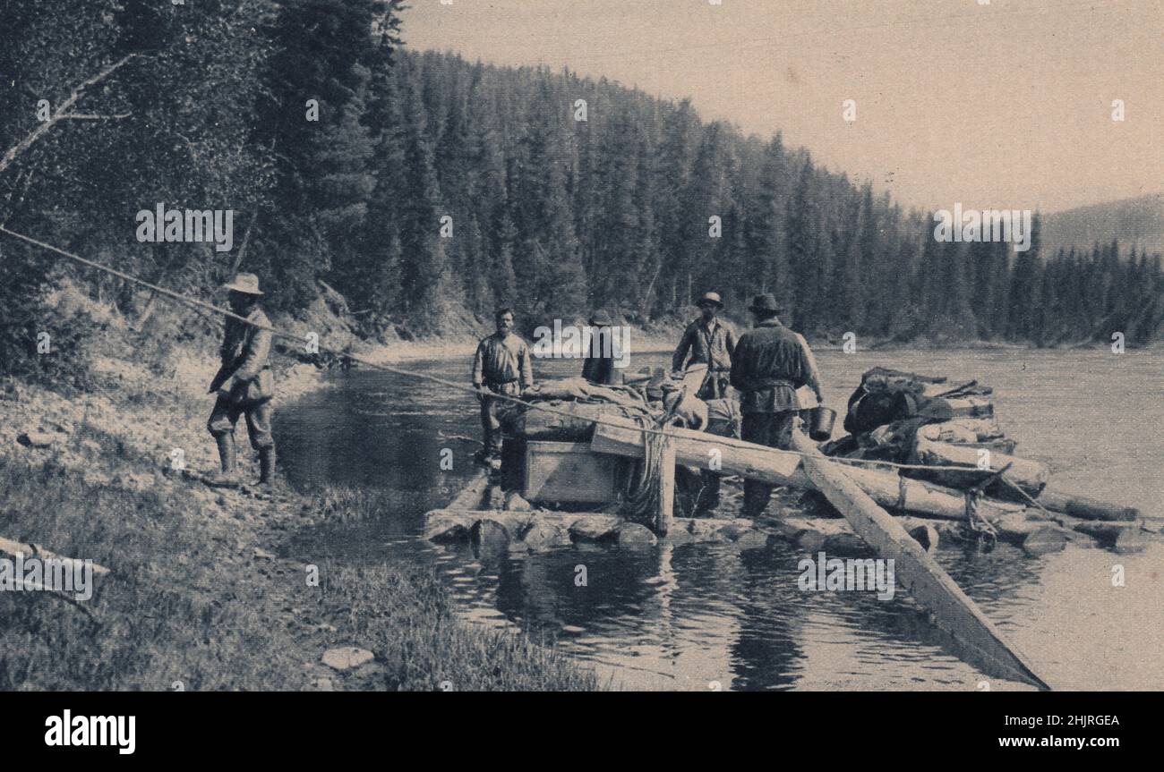Siberian Colonists use rafts of tree trunks to transport them to the upper branches of the Yenisei. Forests of firs & spruce. Mongolia (1923) Stock Photo