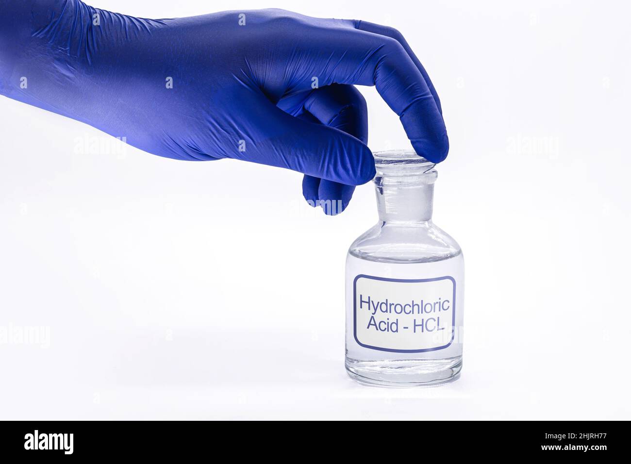 bottle of hydrochloric acid, handling with glove for chemist, chemical solution used in the industry in general, toxic and dangerous product Stock Photo