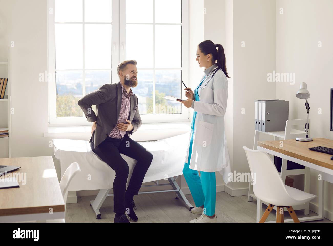 Female doctor examine man having backache or spasm Stock Photo