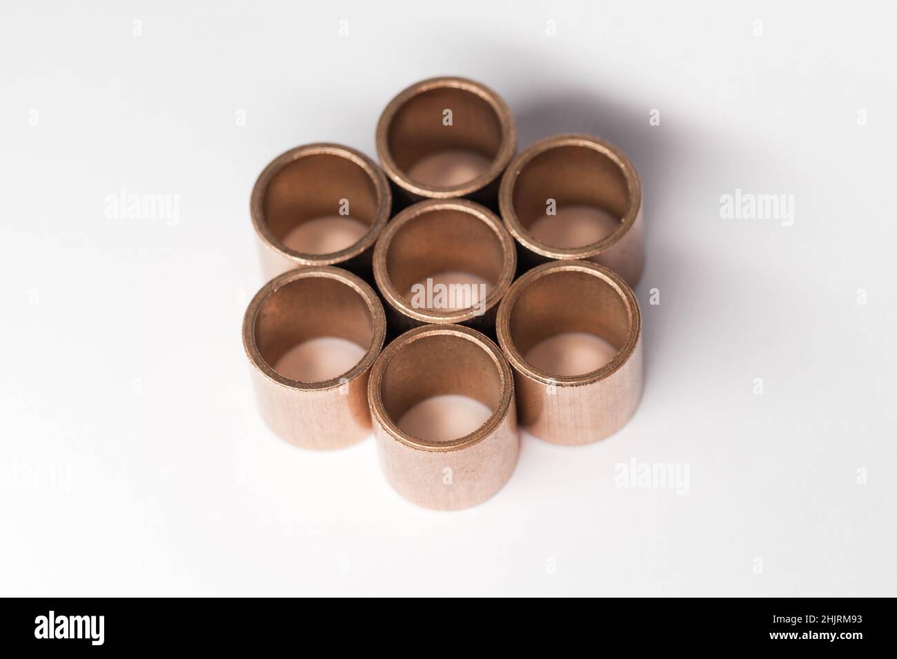 Geometric composition of sleeve bronze bearings on a white background