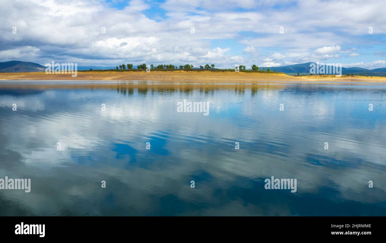 The cloudy sky reflected in the water of the lake Stock Photo - Alamy