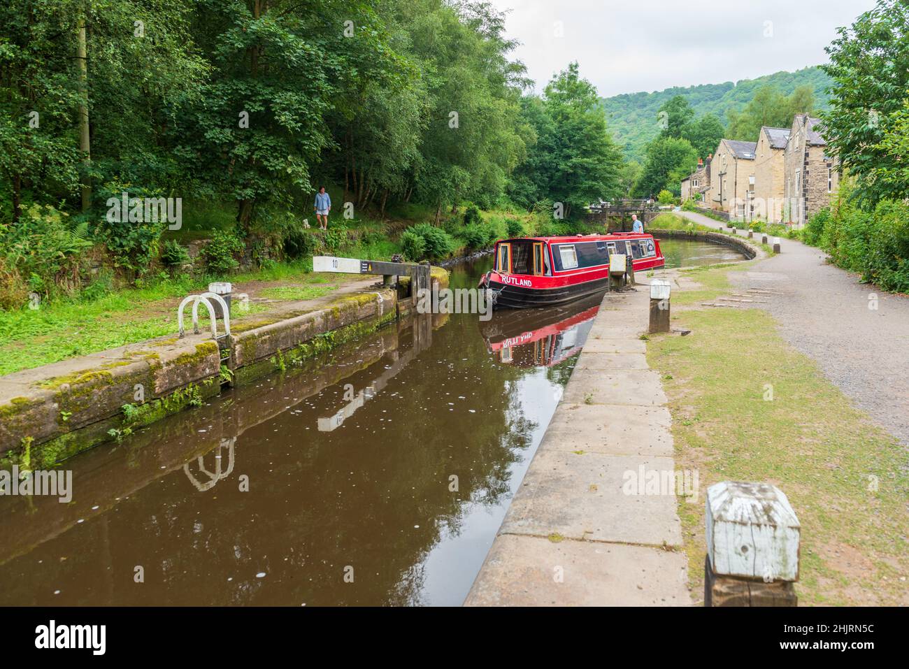 A narrow boat entering the chamber of one of the locks on the Rochdale Canal at Hebden Bridge Stock Photo