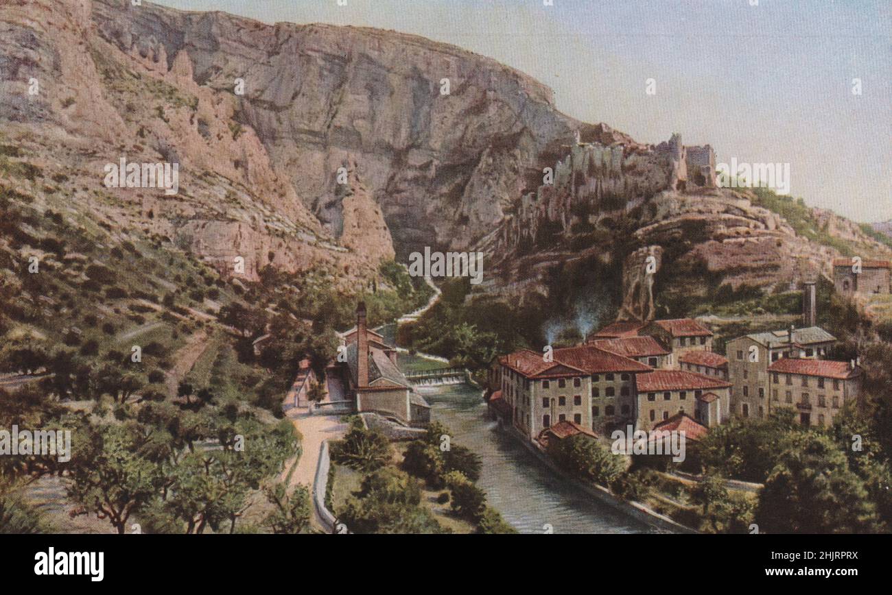 At Fontaine-de-Vaucluse the Sorgue washes the foot of a rocky wall upon which stand the ruins of the Château (1923) Stock Photo