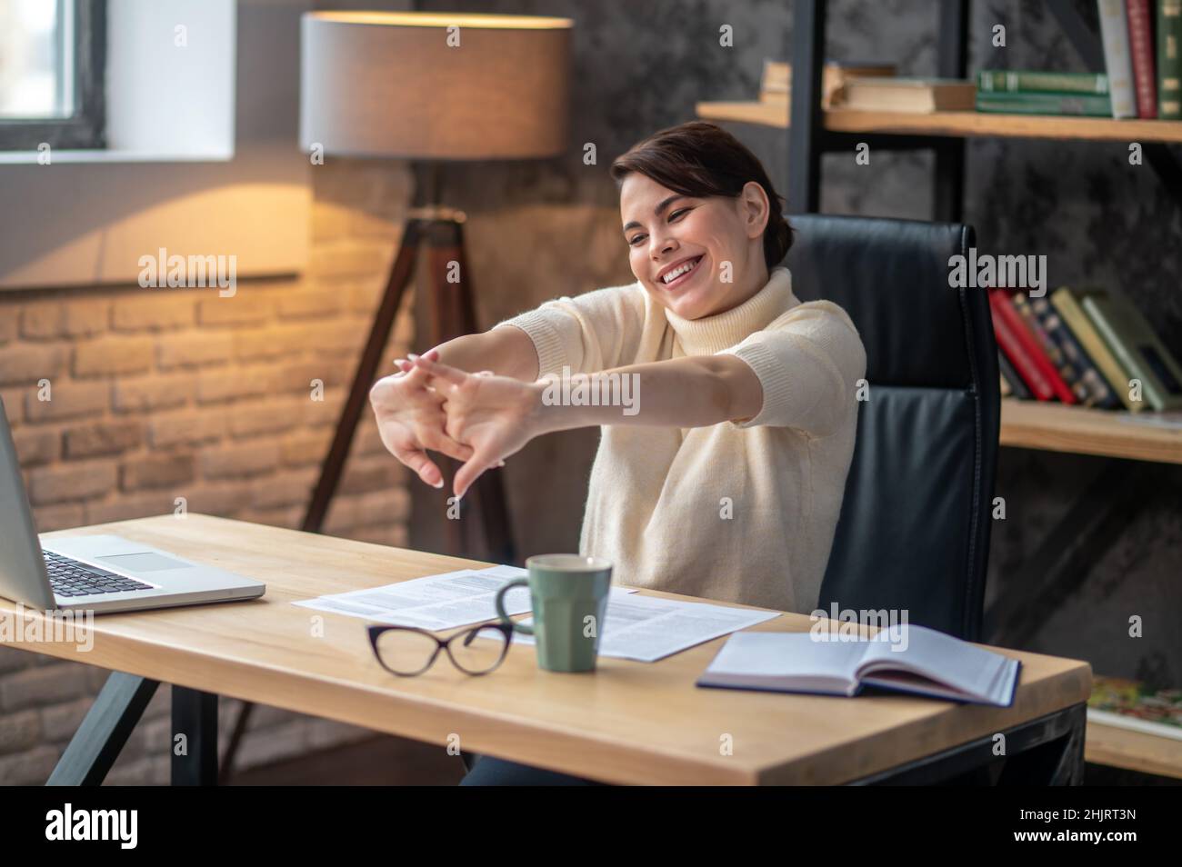 Joyous young woman cracking her knuckles at the desk Stock Photo Alamy