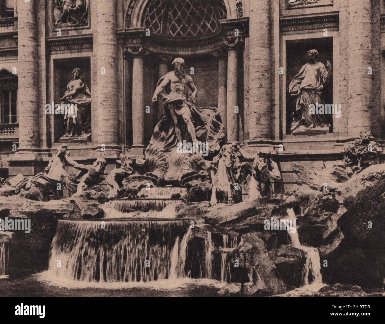 Departing travellers drink the water of the Fontana di Trevi and throw in a coin in the hope that they may revisit the city. Rome (1923) Stock Photo