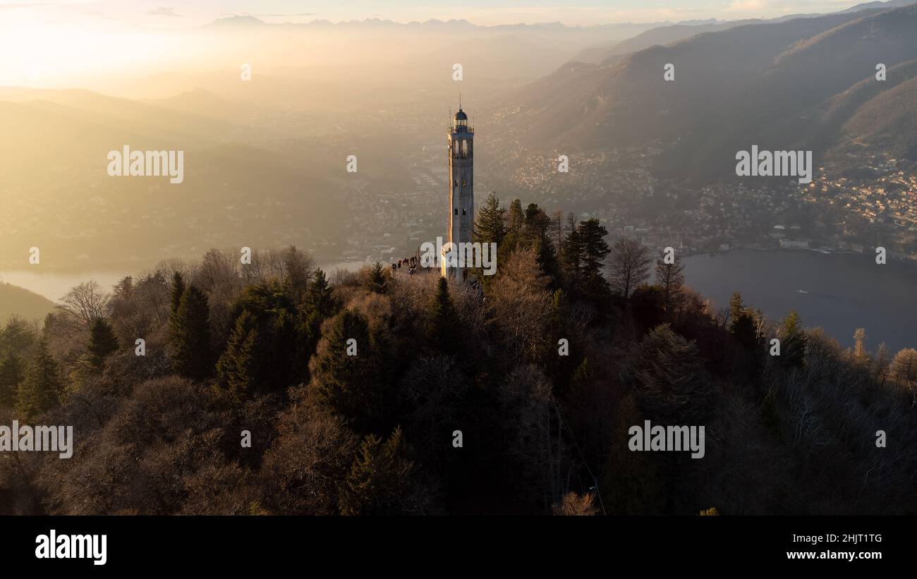 Aerial drone view of a lighthouse over Lake Como skyline with sunset light - Faro Voltiano (Volta Lighthouse) - Travel Destination, Brunate, Como, Lom Stock Photo