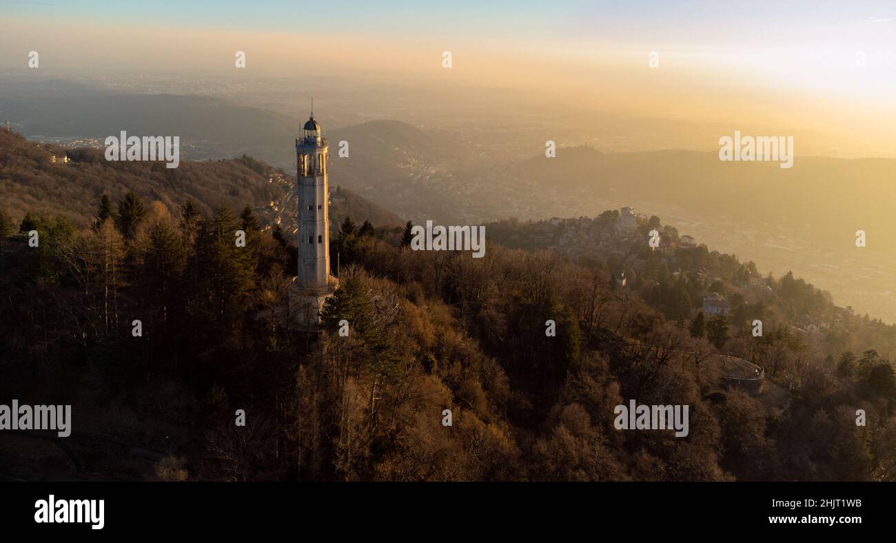 Aerial drone view of a lighthouse  in the middle of the mountains with sunset light - Faro Voltiano (Volta Lighthouse) - Travel Destination, Brunate, Stock Photo