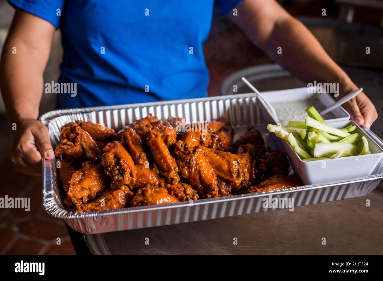 Large tray of buffalo wings with celery and blue cheese Stock Photo