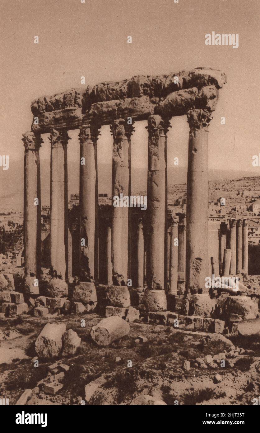 Completed by the Romans about A.D. 217, these columns of the Temple of Jupiter at Baalbek are over sixty feet high. Lebanon. Levant (1923) Stock Photo