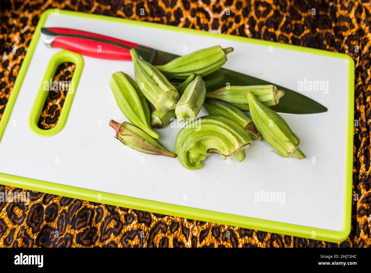 freshly harvested okra on cutting board with knife Stock Photo