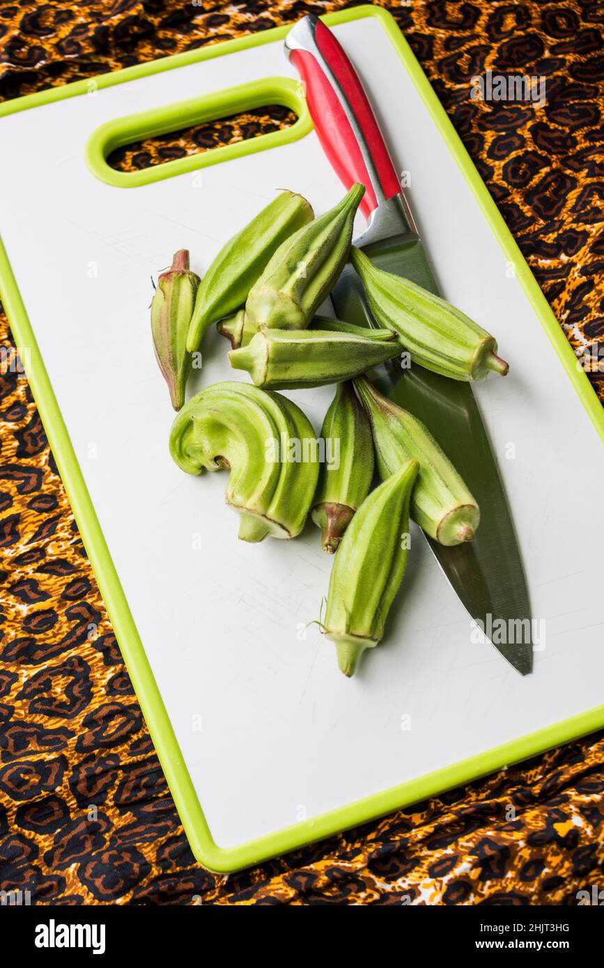 freshly harvested okra on cutting board with knife Stock Photo