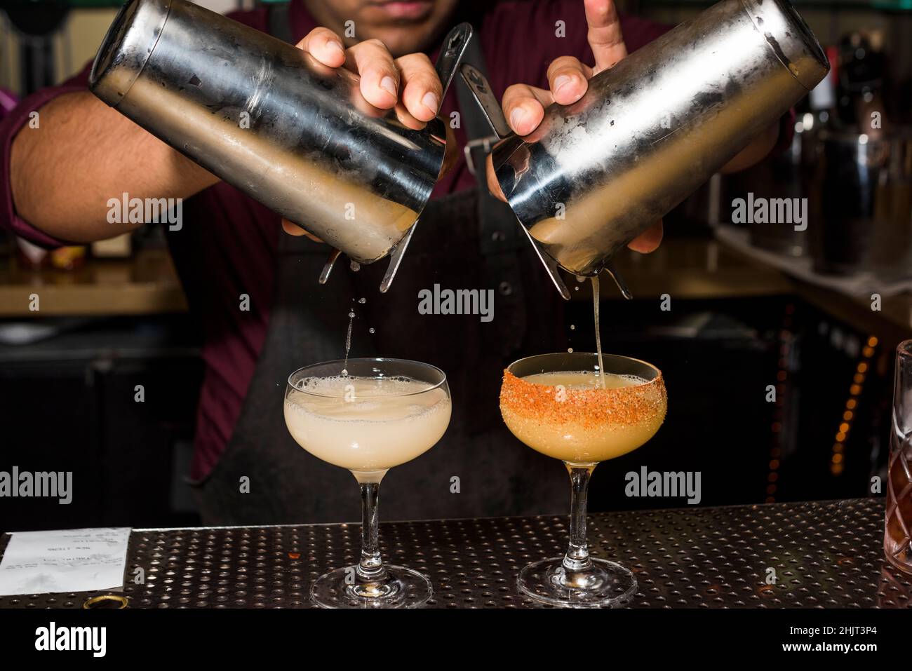 Bartender making fruity cocktails in cocktail lounge Stock Photo