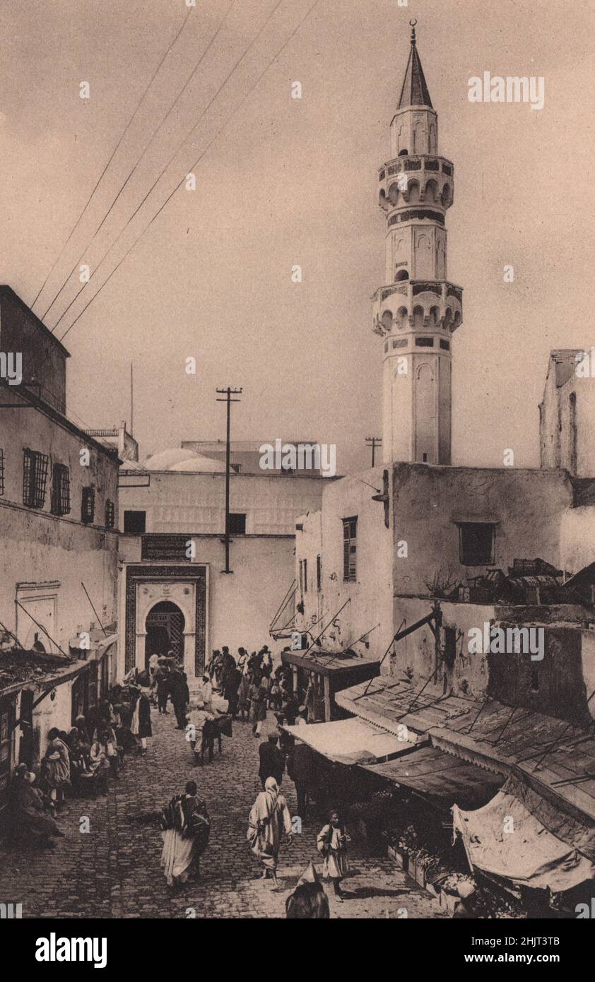TRIPOLI. Country and capital are named alike. Here the Strada della Marina frames the Mauresque entrance to the Gurji Mosque. Libya (1923) Stock Photo