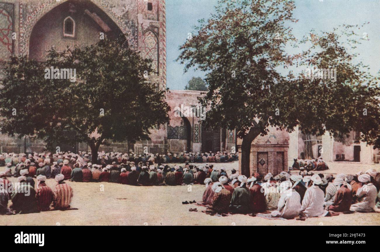 Lines of cast slippers & bodies bowed & raised in unison colour a mosque courtyard in Samarkand. Uzbekistan (1923) Stock Photo