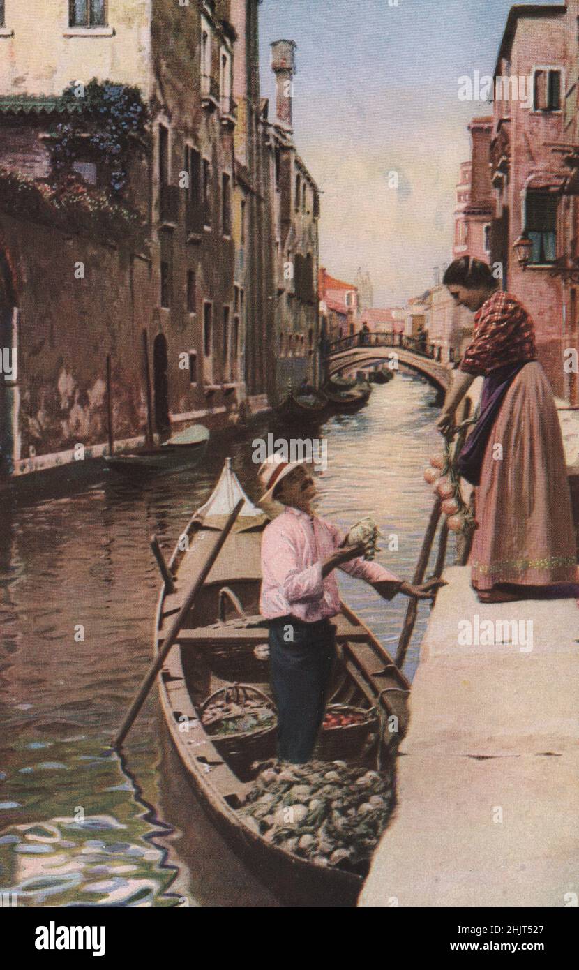 That this canal is not deep is shown by the oar thrust to the bottom while the gondolier-greengrocer is selling a cabbage. Venice (1923) Stock Photo