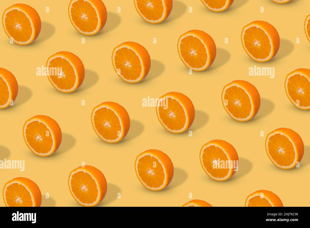 Fresh sliced orange on bright yellow background. Fruit pattern, creative summer concept. Pop art design, creative summer concept. Stock Photo