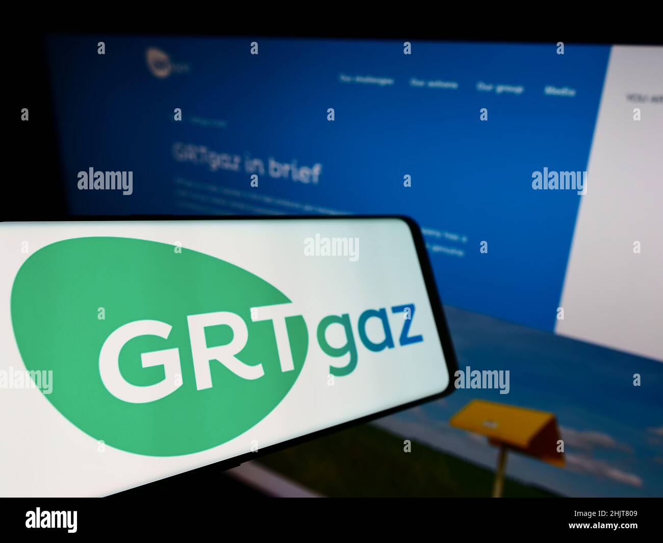 Cellphone with logo of French natural gas company GRTgaz S.A. on screen in front of business website. Focus on left of phone display. Stock Photo