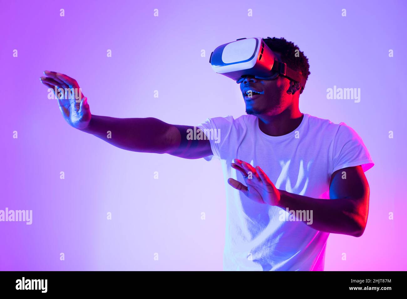 Excited African American guy in VR headset using virtual reality ...