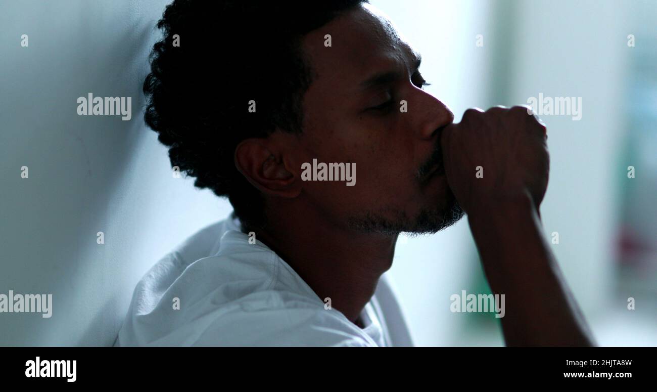 Worried black man feeling distraught and preoccupied sitting on home ...