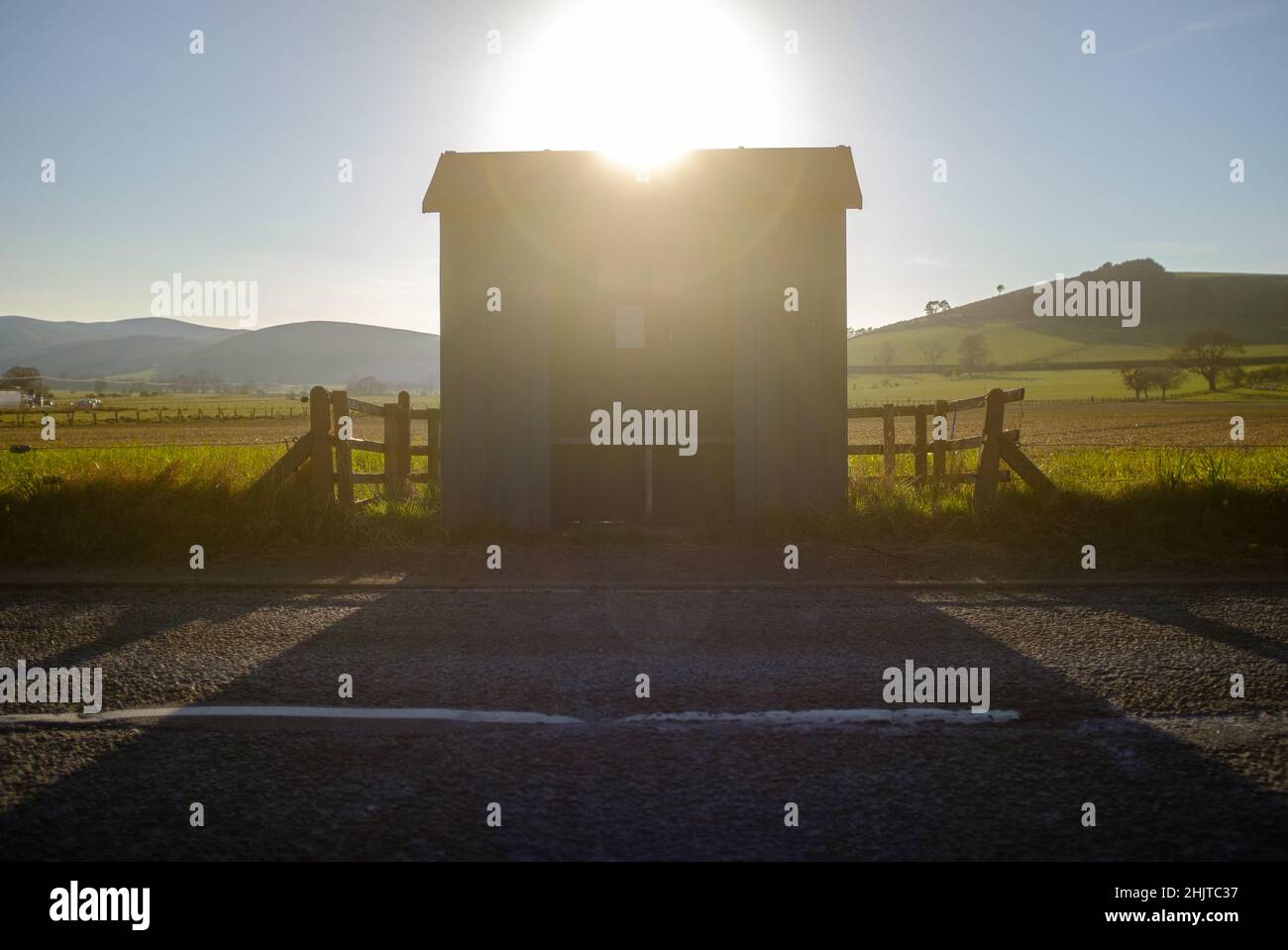 The Sun Setting Over A Rural Bus Stop In Scotland Stock Photo