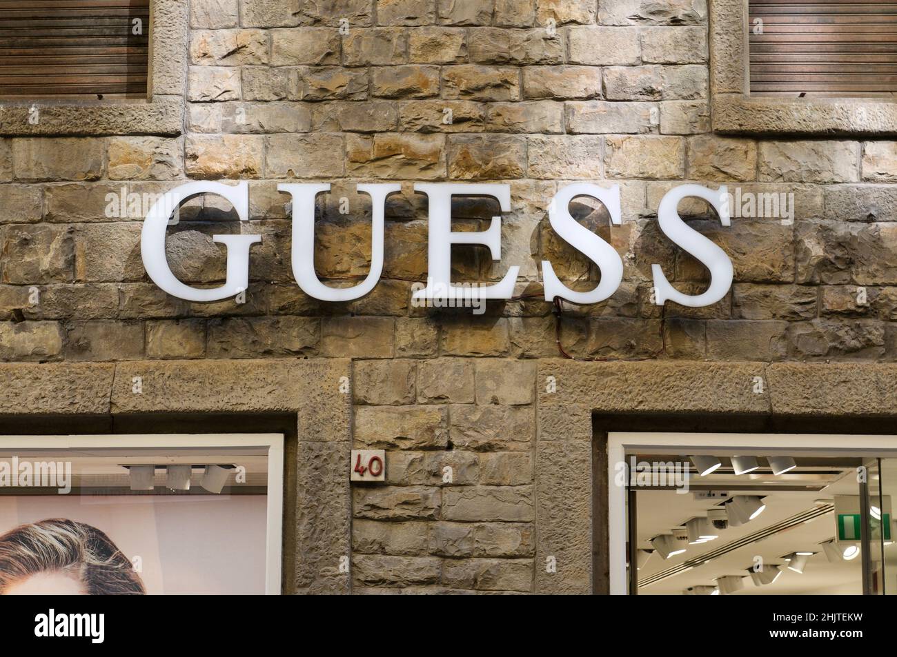 Firenze, Tuscany, Italy - 27th September 2021 : Illuminated GUESS sign hanging in on a store in Florence, Italy. Guess is an American clothing brand a Stock Photo