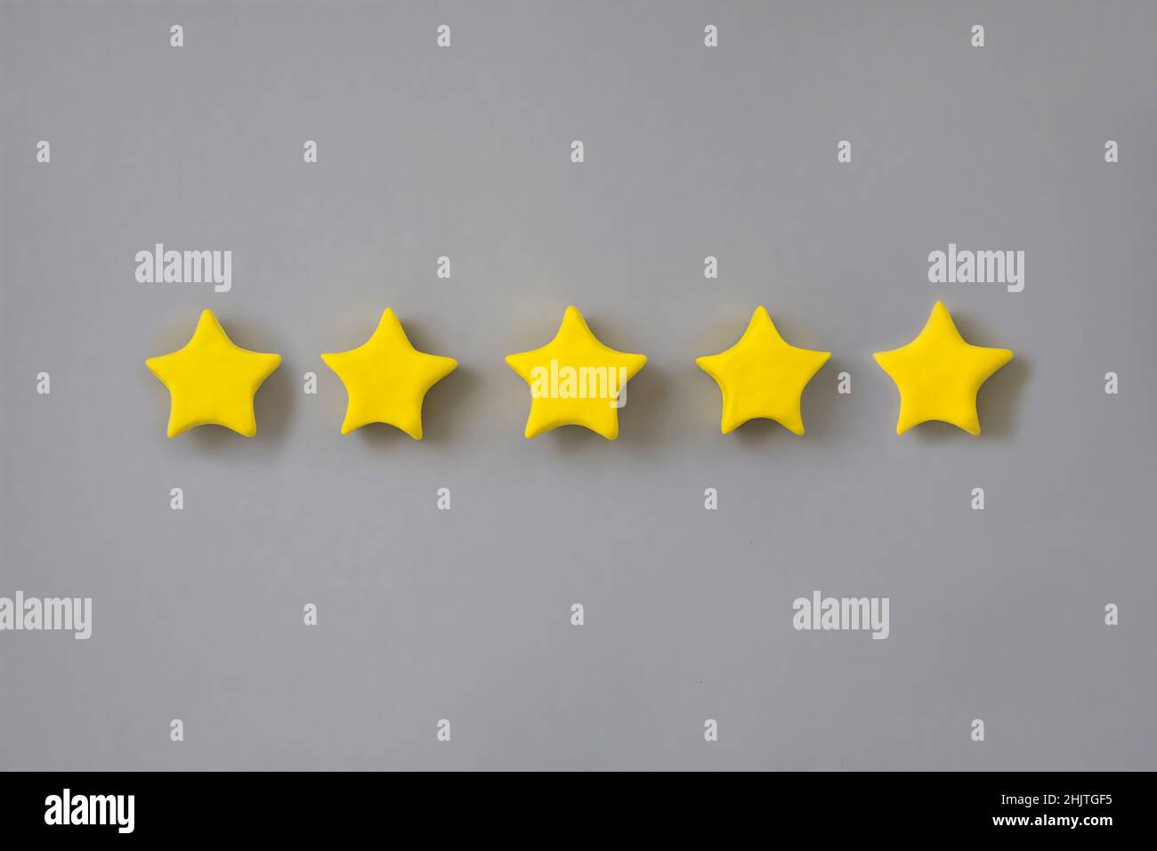 Five star in a row on grey background. Golden star shape. Concept of top class, best quality product symbol. Sign of  evaluation, feedback from custom Stock Photo