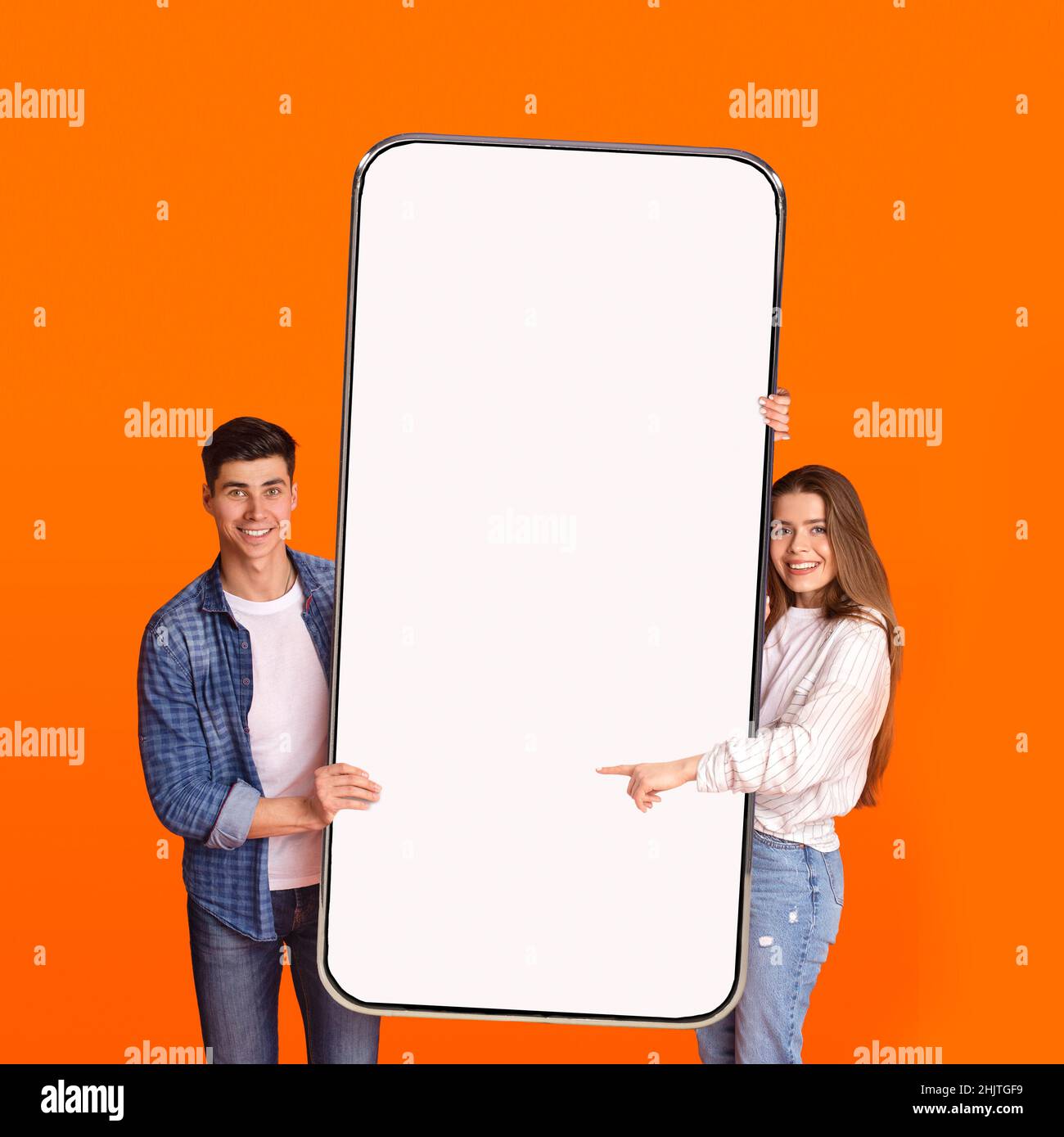 Excited couple pointing at white empty smartphone screen Stock Photo