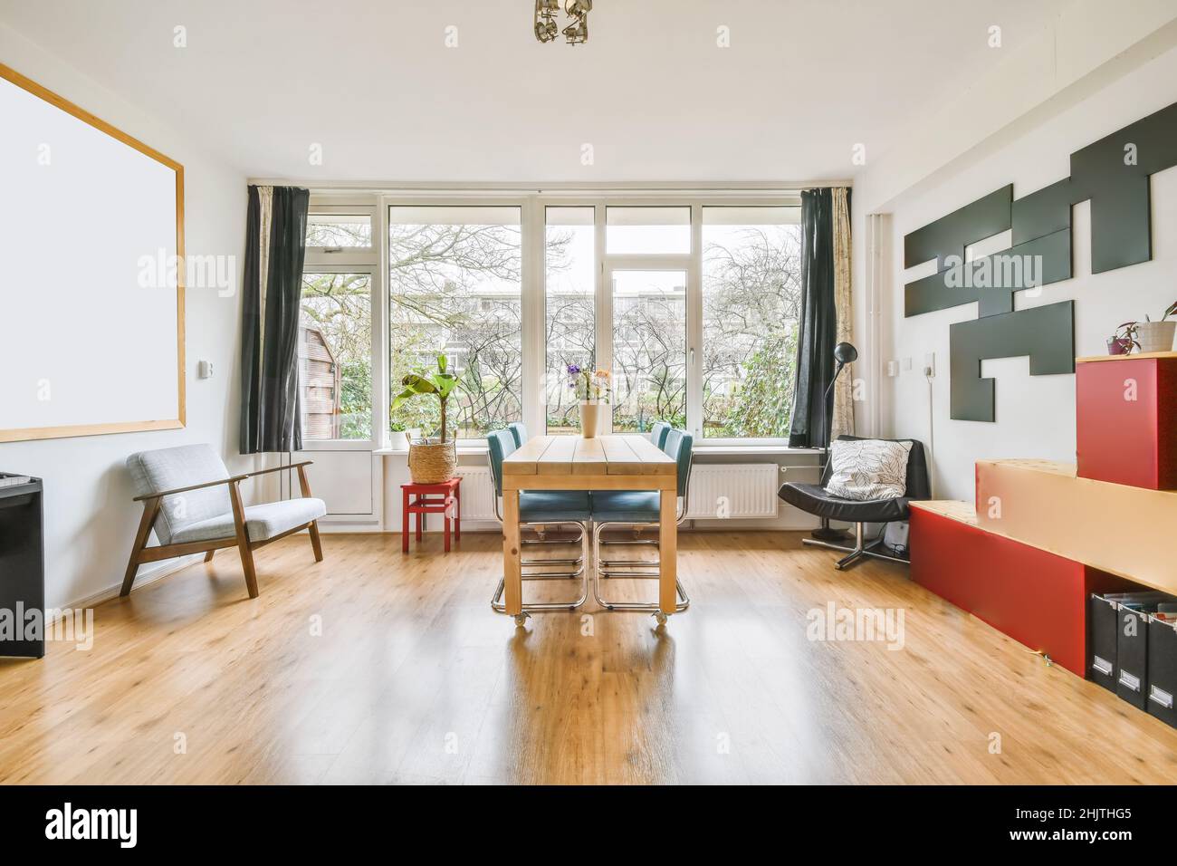Charming room with large windows and a wooden table with blue chairs ...