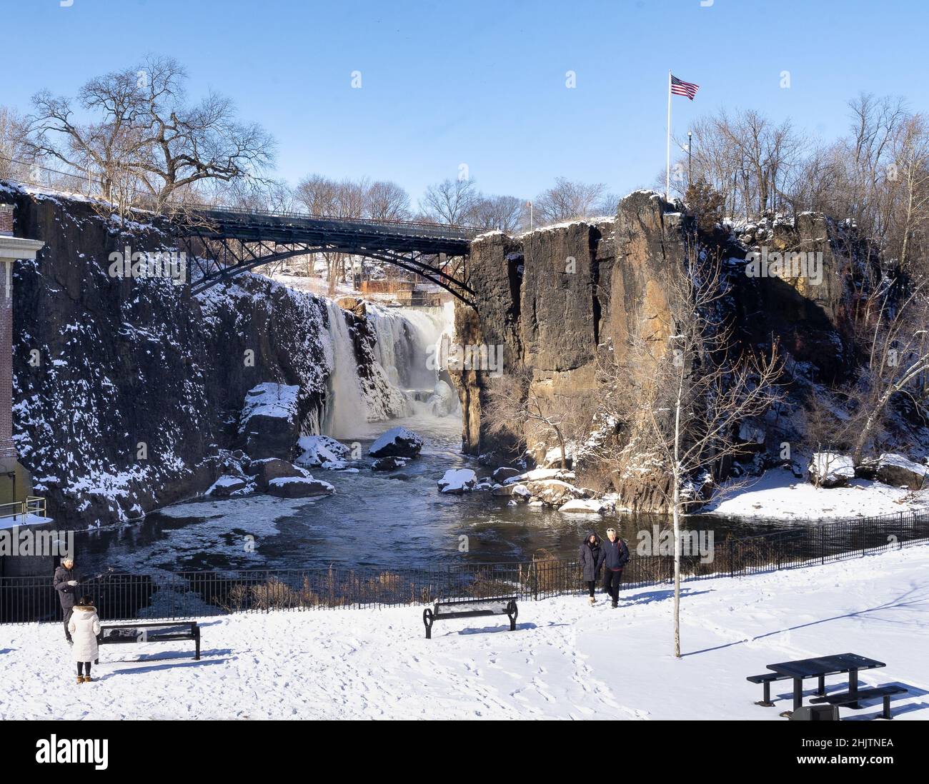 Paterson, NJ - USA - Jan 30, 2022 Wide horizontal view of tourists viewing the partially frozen falls at the historic Paterson Great Falls National Hi Stock Photo